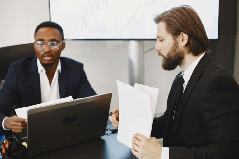 deux hommes en costumes dans une salle de travail