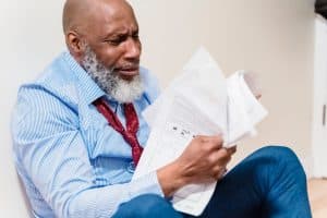 Salarié inquiet lisant sa lettre de licenciement pendant arrêt maladie
